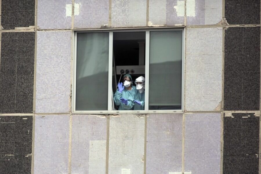 Врачи машут из окна госпиталя в Мадриде.