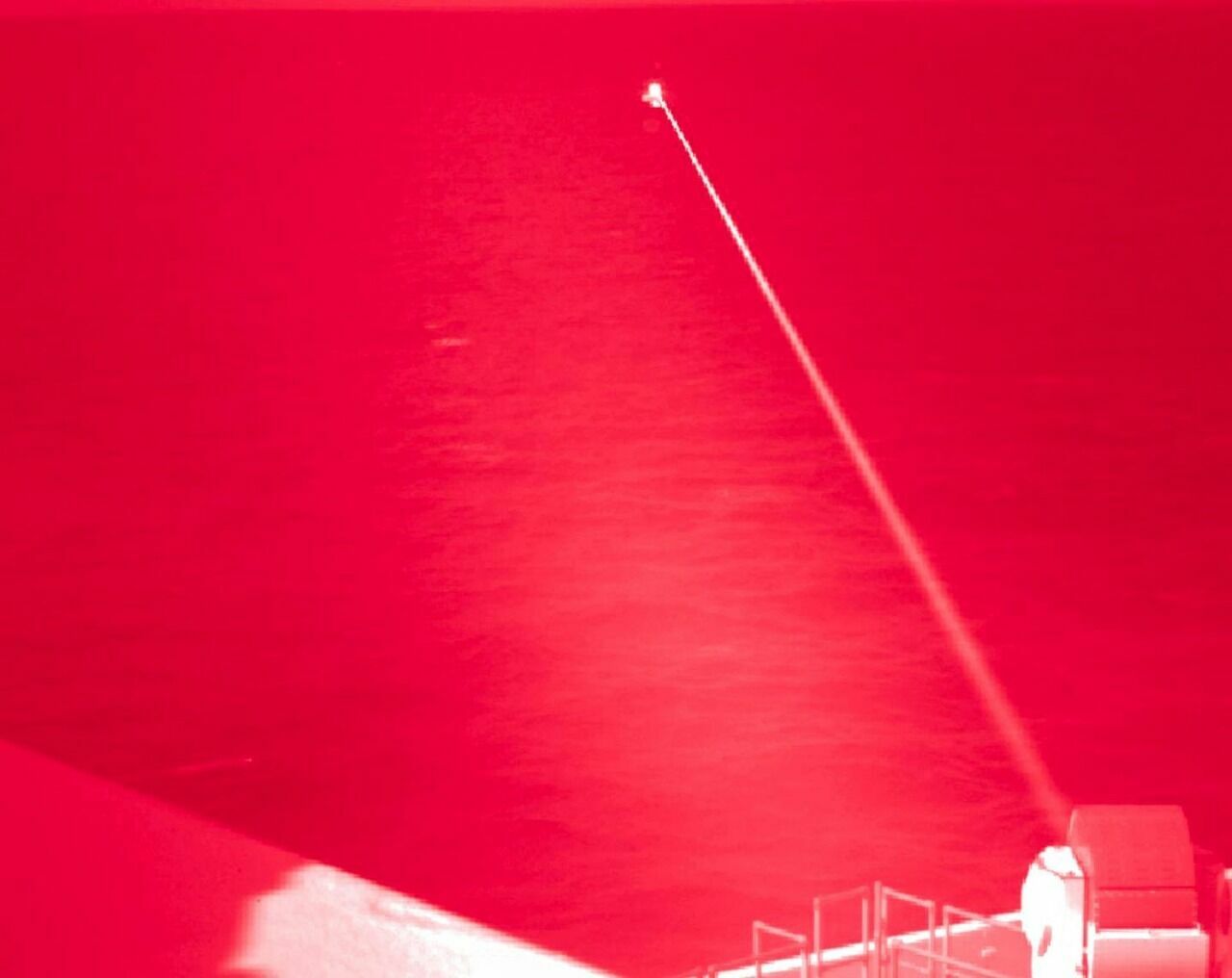 Это снимок сделан в инфракрасном диапазоне, чтобы был виден луч лазера, уничтожающий надводную цель.